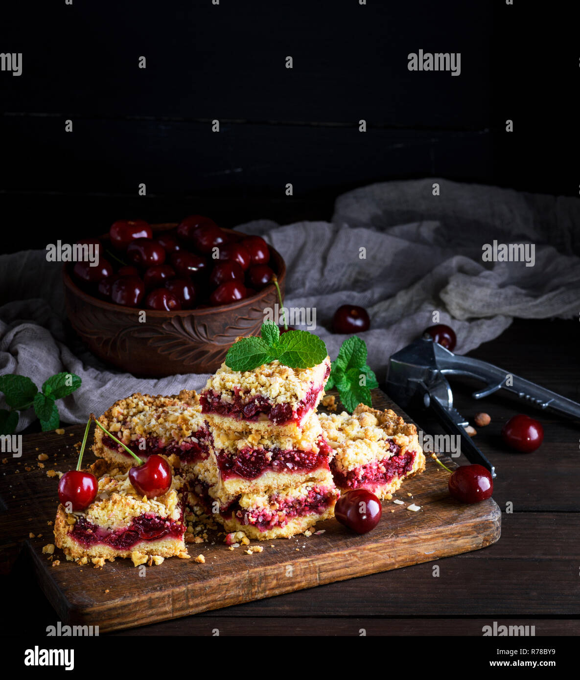 baked cake with cherry and ceramic bowl with fresh berries Stock Photo