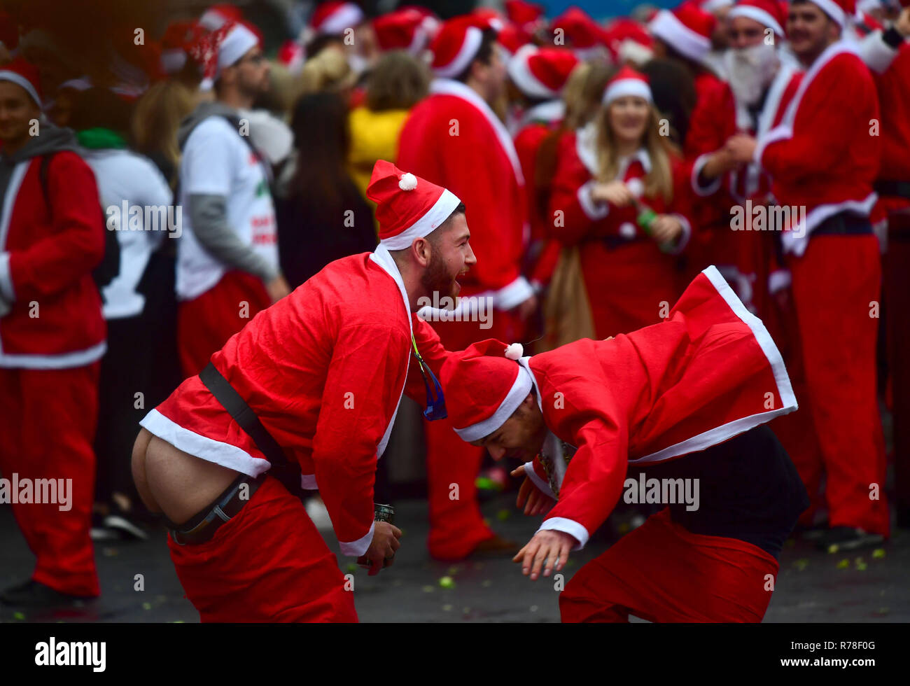 Participants in Santa costumes outside London King's Cross railway station as they make their way through the streets of London as they take part in Santacon London 2018. Stock Photo