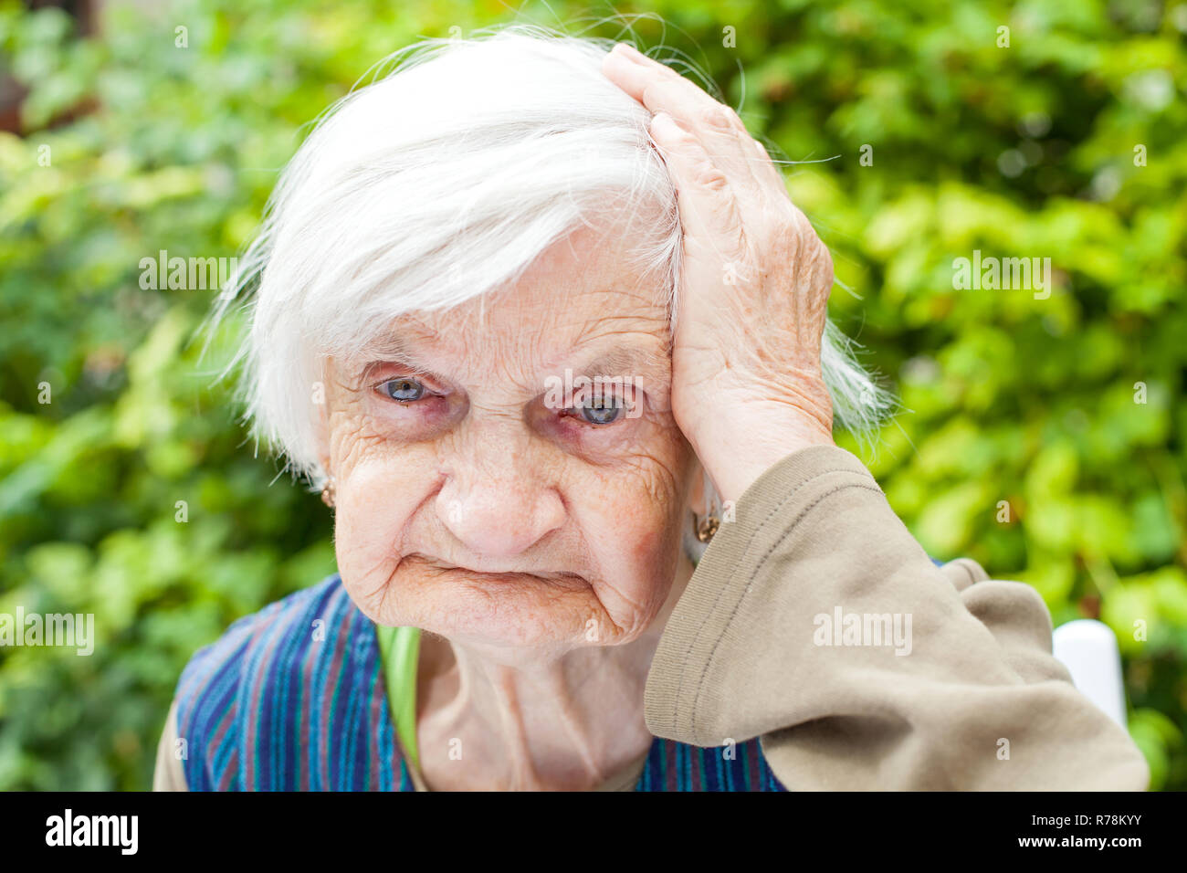 Photo of a senior woman touching her head Stock Photo