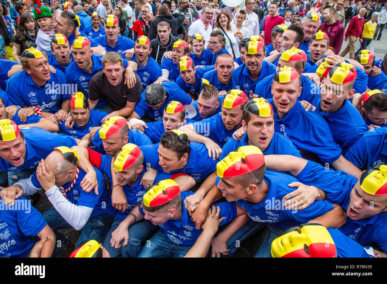 Crowd with the Belgian flag as a mask on their heads, Doudou city festival in Grand Place square, Mons, Belgium Stock Photo