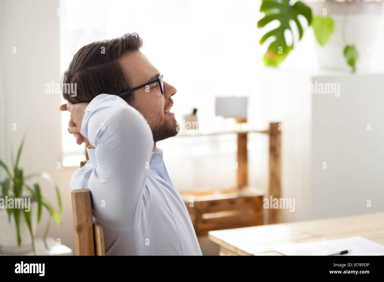 Calm male employee relax in chair with eyes closed Stock Photo