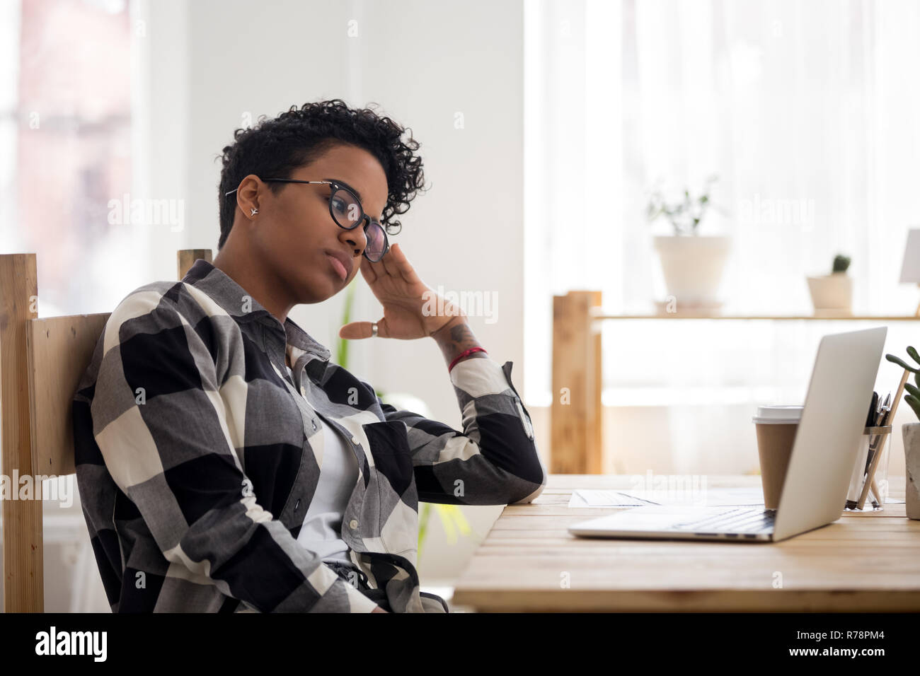 African American girl feel bored sitting at workplace Stock Photo