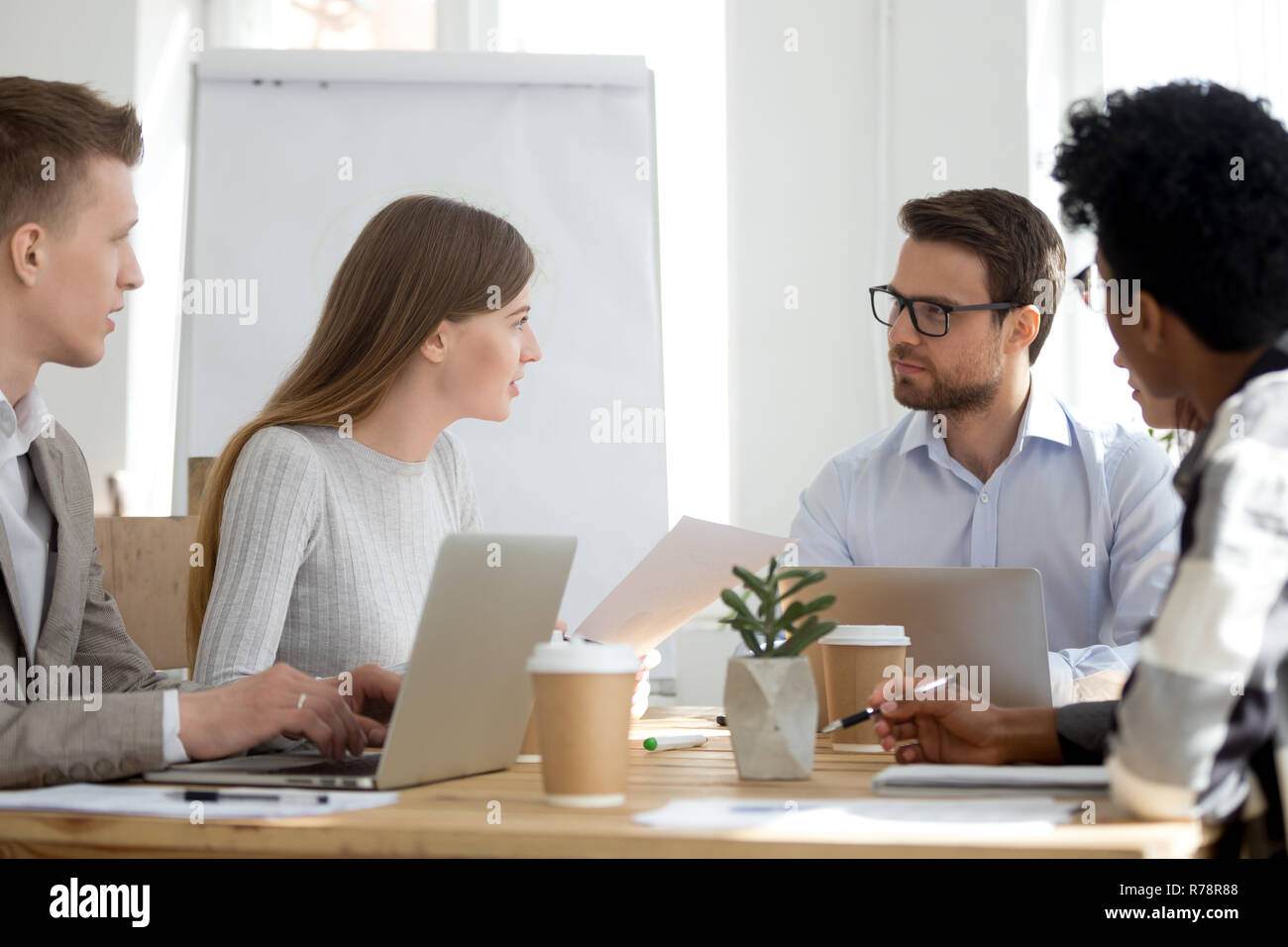 Diverse employees sit at meeting collaborating in office Stock Photo ...