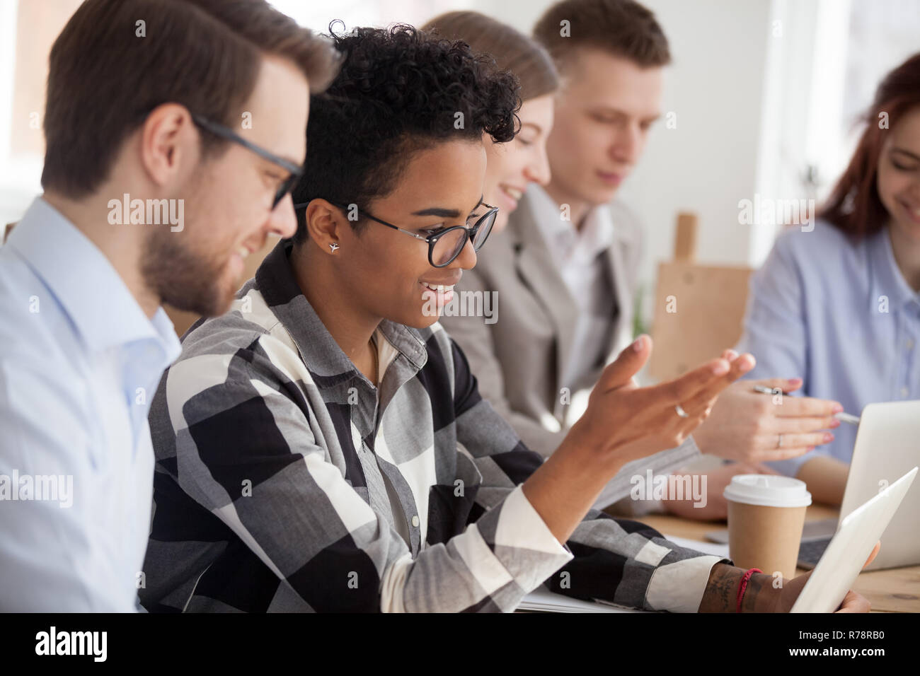 Smiling diverse employees work at laptops at meeting Stock Photo - Alamy