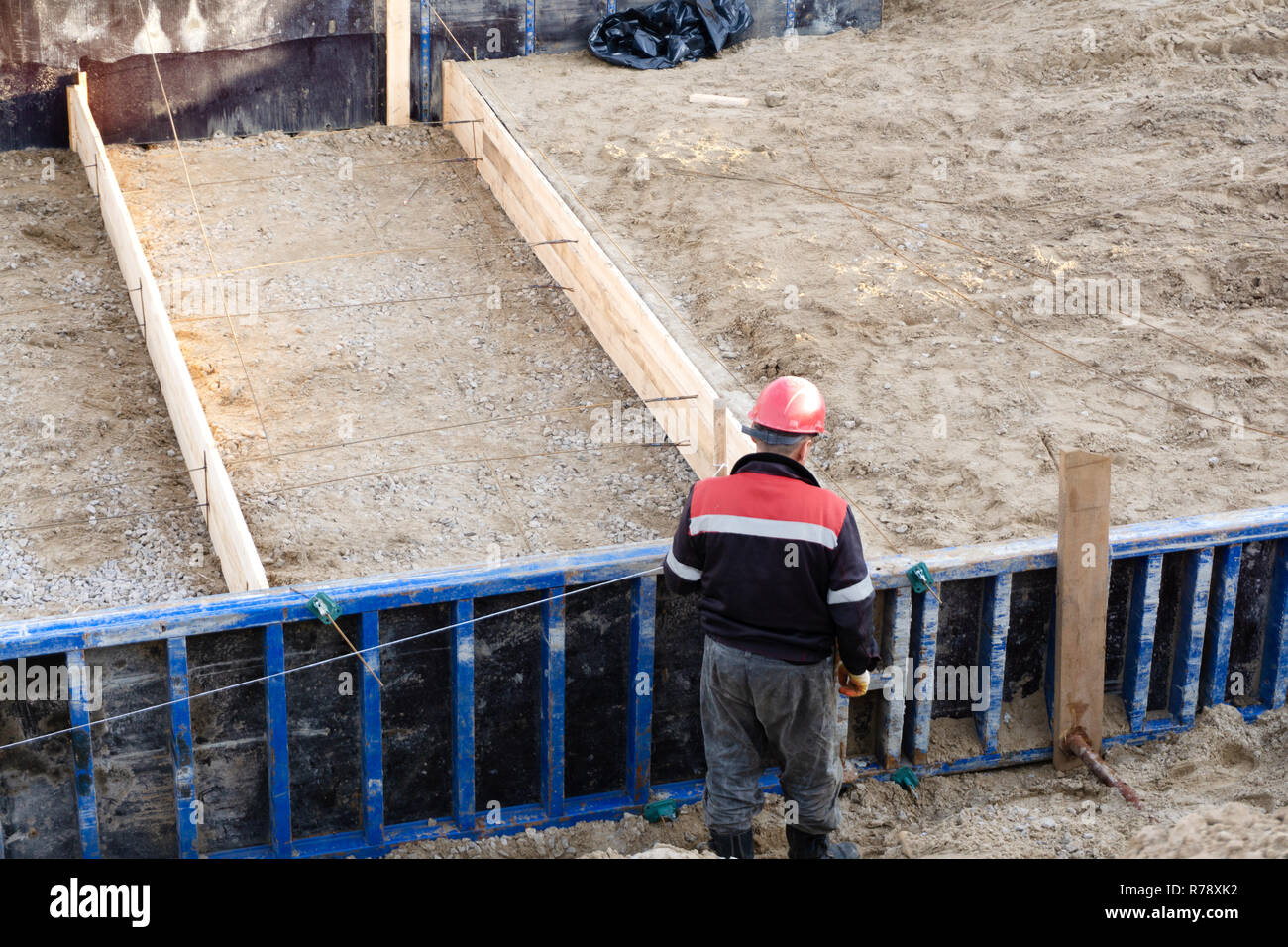 workers on a construction site to make the cement Foundation for the ...