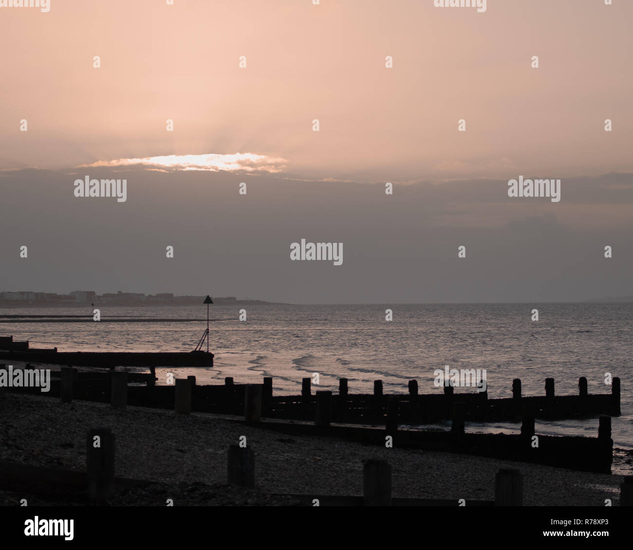 Sunset on a Uk beach with wooden beach Groynes Stock Photo