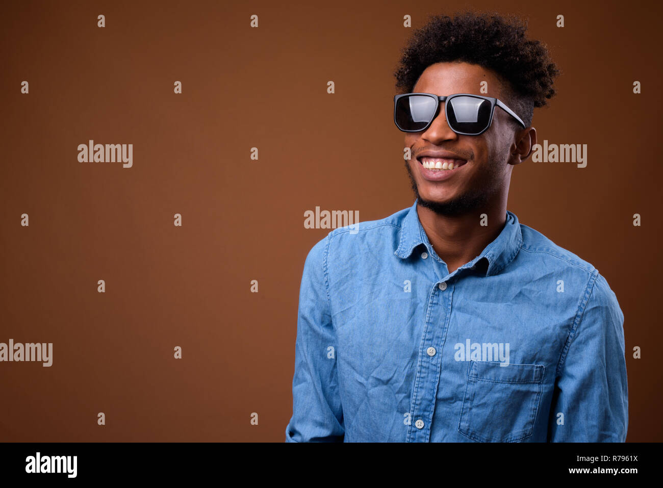 Young happy African man thinking and smiling Stock Photo - Alamy