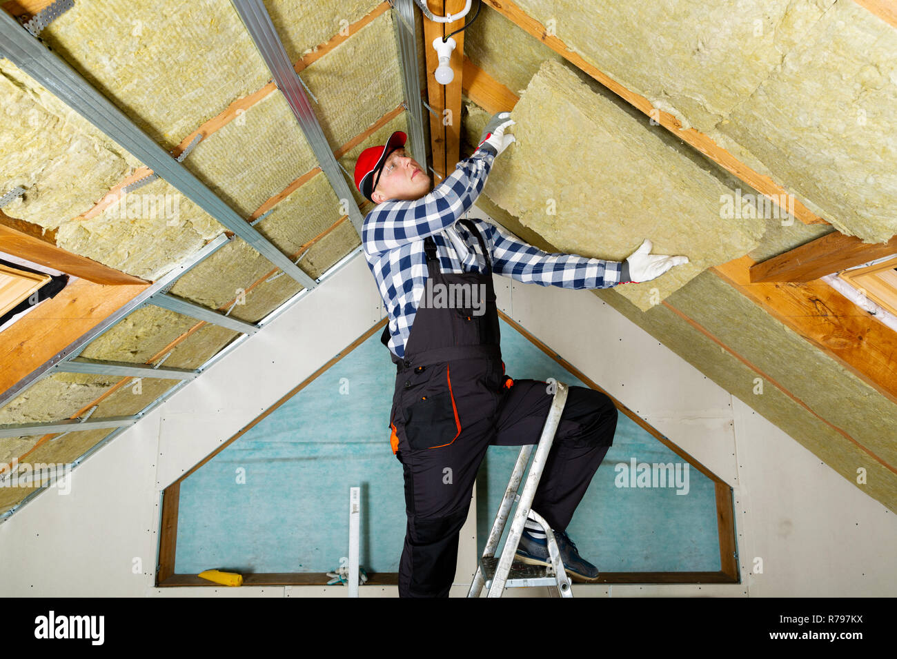 Man Installing Thermal Roof Insulation Layer Using Mineral