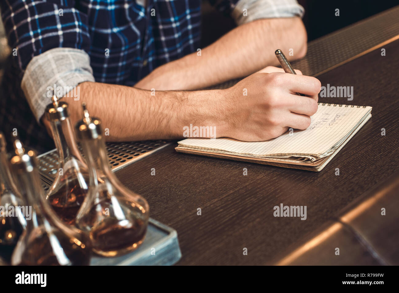 Young bartender leaning on bar counter writing inventory close-up Stock ...