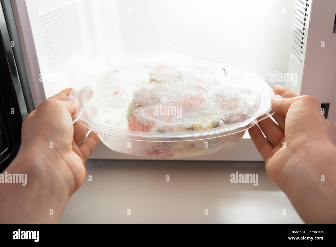 Woman Heating Food In Microwave Oven Stock Photo Alamy