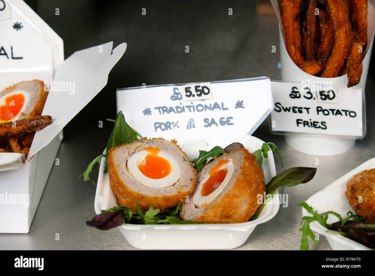 Scotch egg on stall with pork and sage stuffing and sweet potato fries  for sale at Borough Market in London England UK Great Britain    KATHY DEWITT Stock Photo