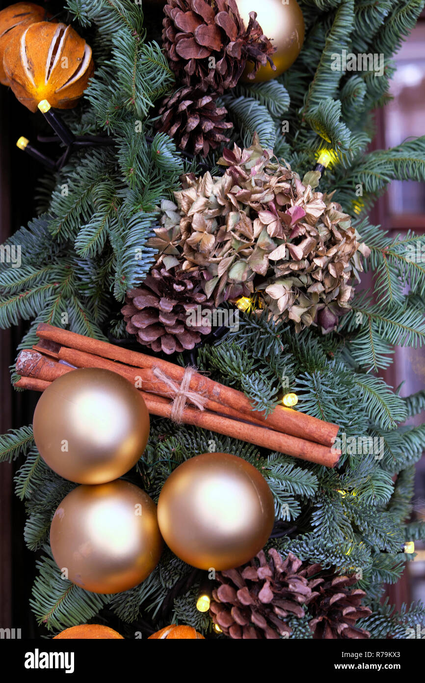 Gold Christmas baubles, cinnamon sticks, orange peel and dried hydrangea on fir tree branches wreath in the City of London England UK  KATHY DEWITT Stock Photo
