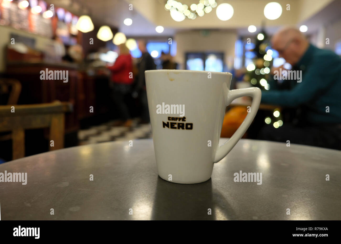 Cafe Nero coffee cup on a table inside shop store interior and blurred Christmas tree decorations in Cardiff Wales UK. KATHY DEWITT Stock Photo