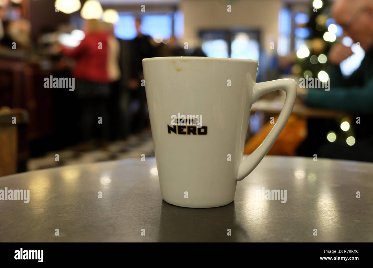 Cafe Nero coffee cup on a table inside shop store interior and blurred Christmas tree decorations in Cardiff Wales UK. KATHY DEWITT Stock Photo