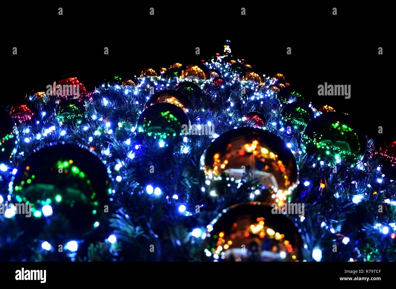 Festive Christmas tree decorated with large bright balls and a garland ...