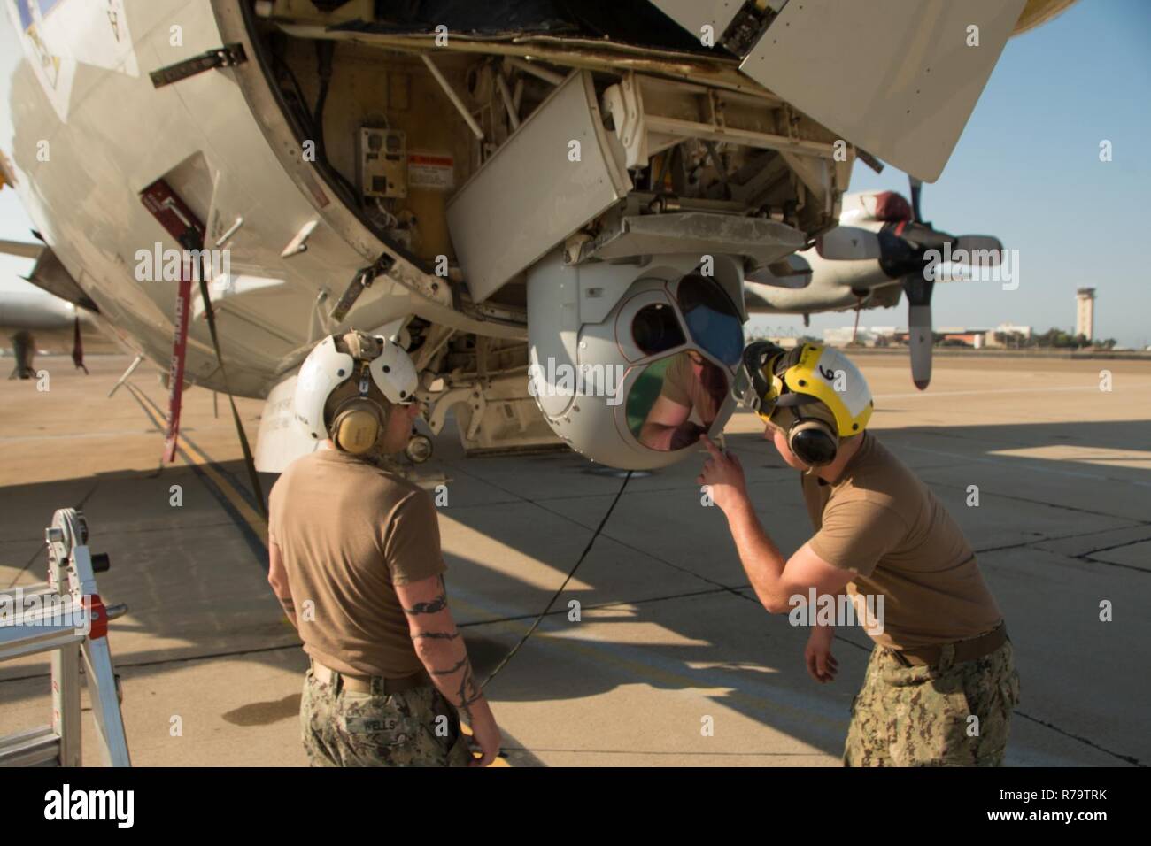 SAN DIEGO (April 11, 2017) Aviation Electronics Technician 1st Class Thomas Wells (left) and Airman Aviation Electronics Technician Nathan McDaniel, attached to Patrol Squadron (VP) 40, inspect the ASX-4 Advanced Imaging Multi Spectral Sensor Turret on a P-3 Orion Aircraft. VP-40 has detached aircraft and personnel to Naval Air Station North Island to support Carrier Strike Group 11 in their Joint Task Force Exercise. Stock Photo