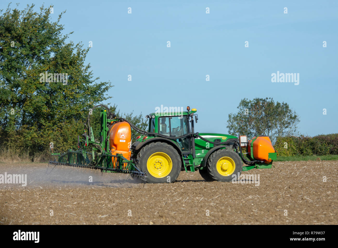 Tractor spraying field Stock Photo