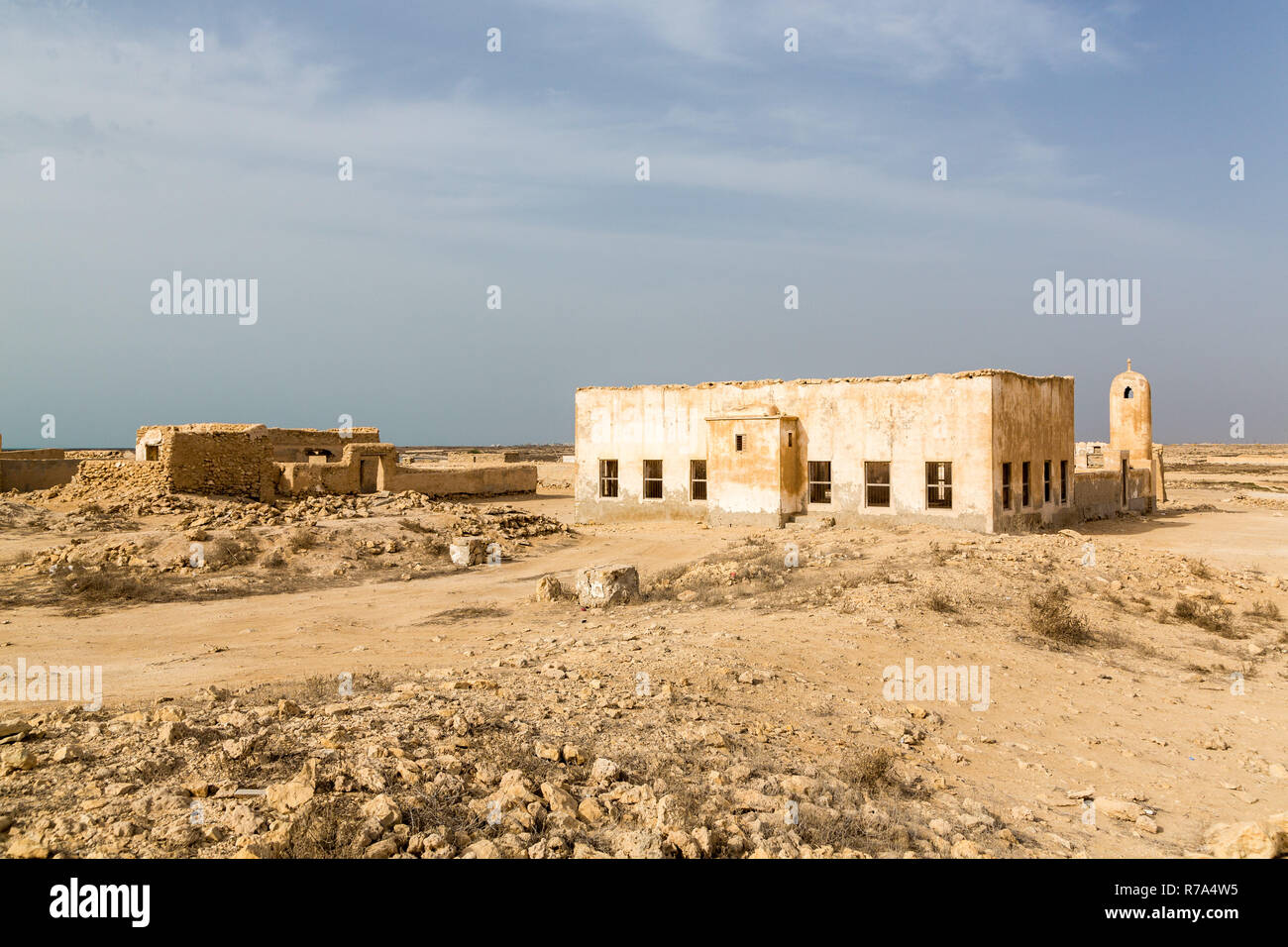 Ruined ancient old Arab pearling and fishing town Al Jumail, Qatar. The desert at coast of Persian Gulf. Abandoned mosque with minaret. Pile of stones Stock Photo