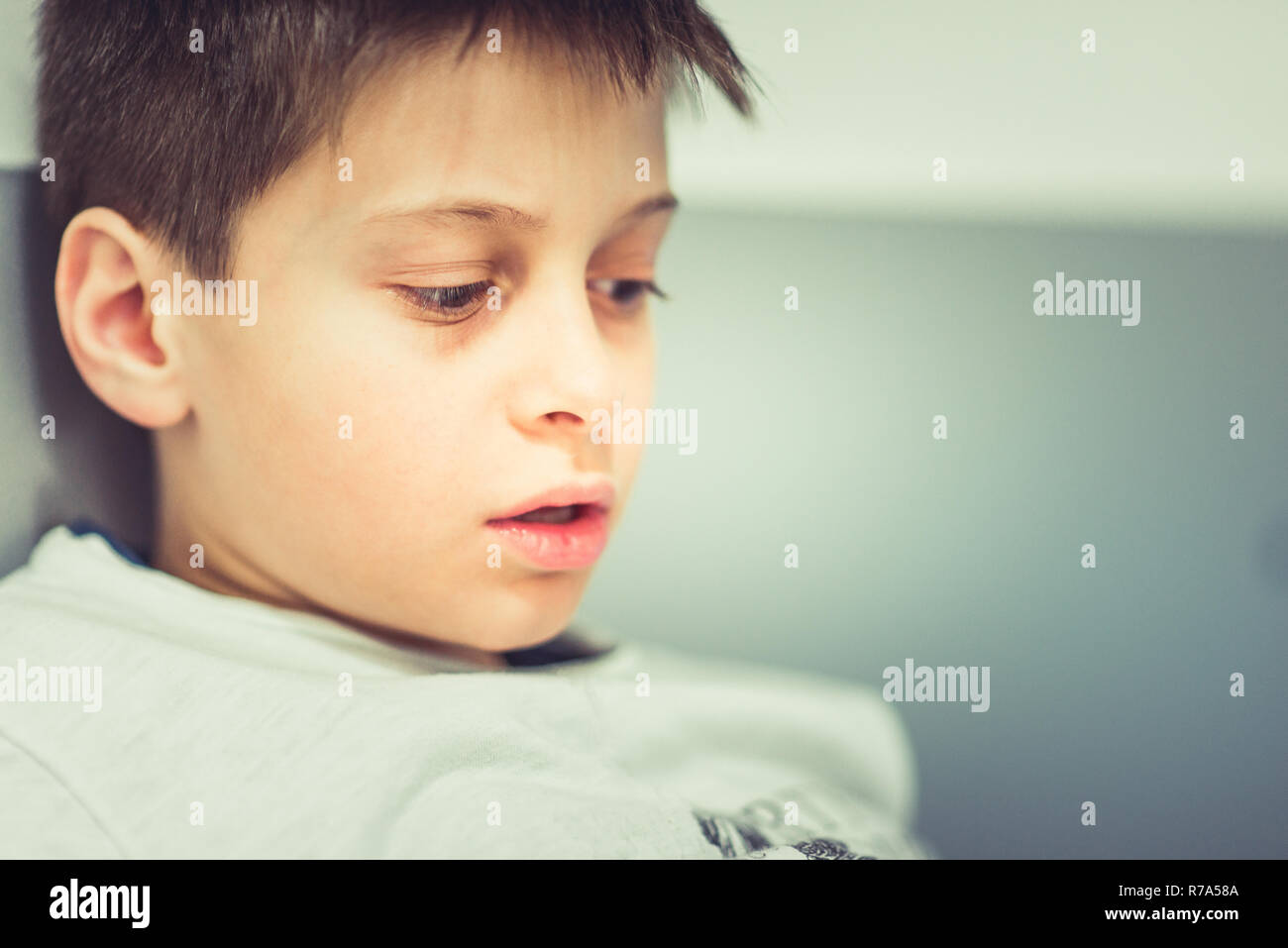 A boy is sitting on the sofa and looking front Stock Photo - Alamy