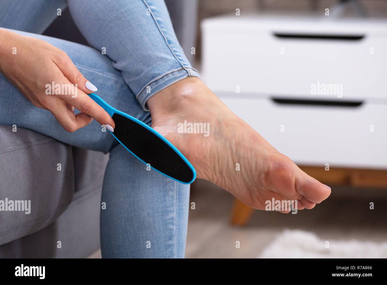 Close-up Of A Woman's Hand Filling Foot With Foot File Stock Photo