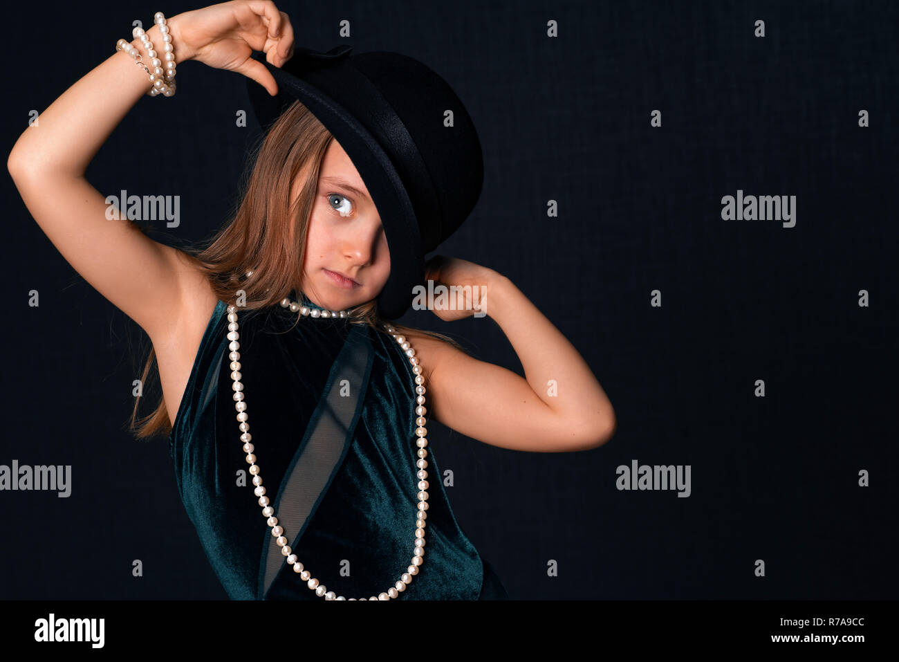 Little girl in a black hat and white beads.Portrait of a beautiful ...