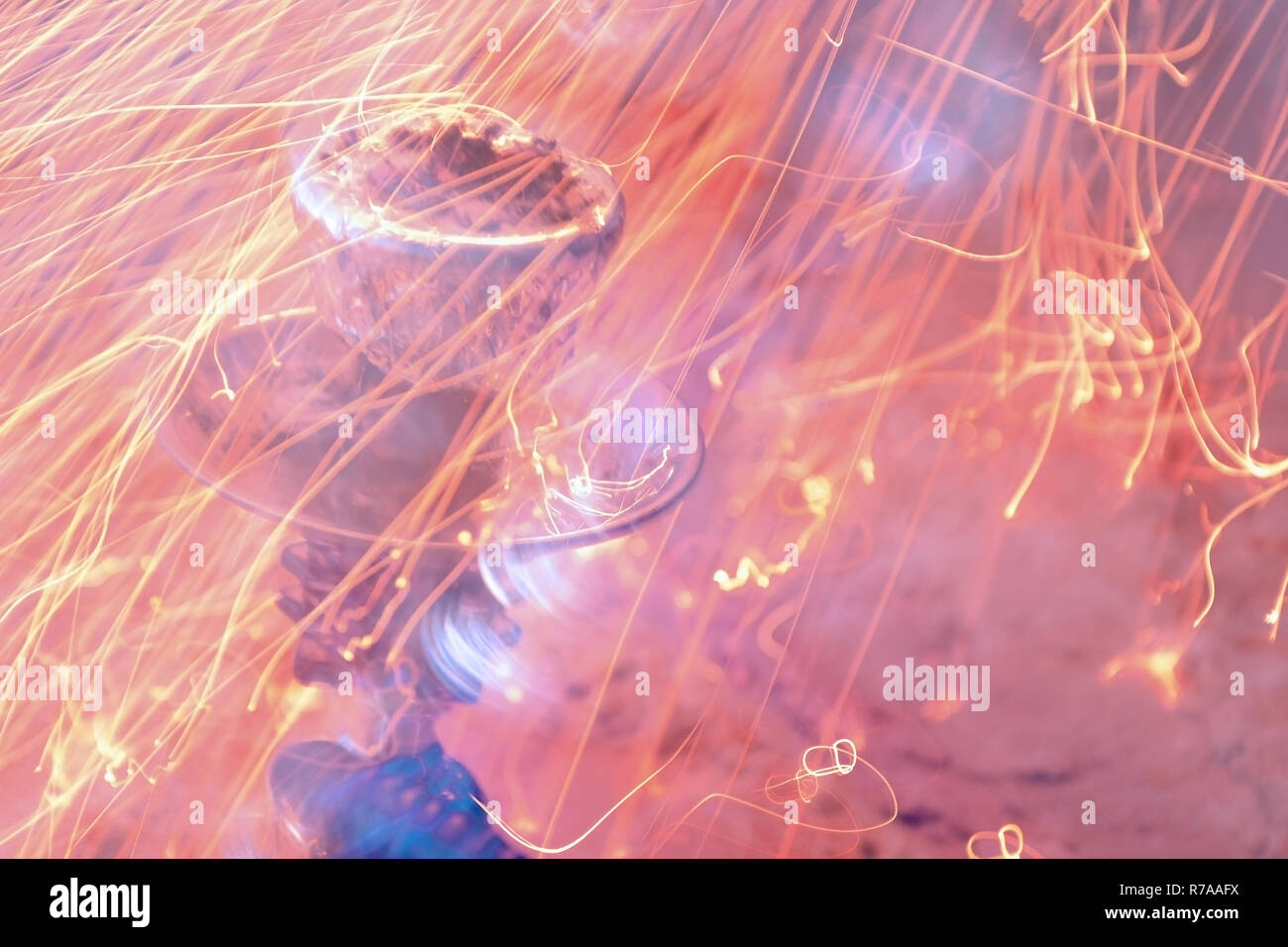 metal stand, bowl of hookah with foil and coals. Sparks of fire on the background Stock Photo