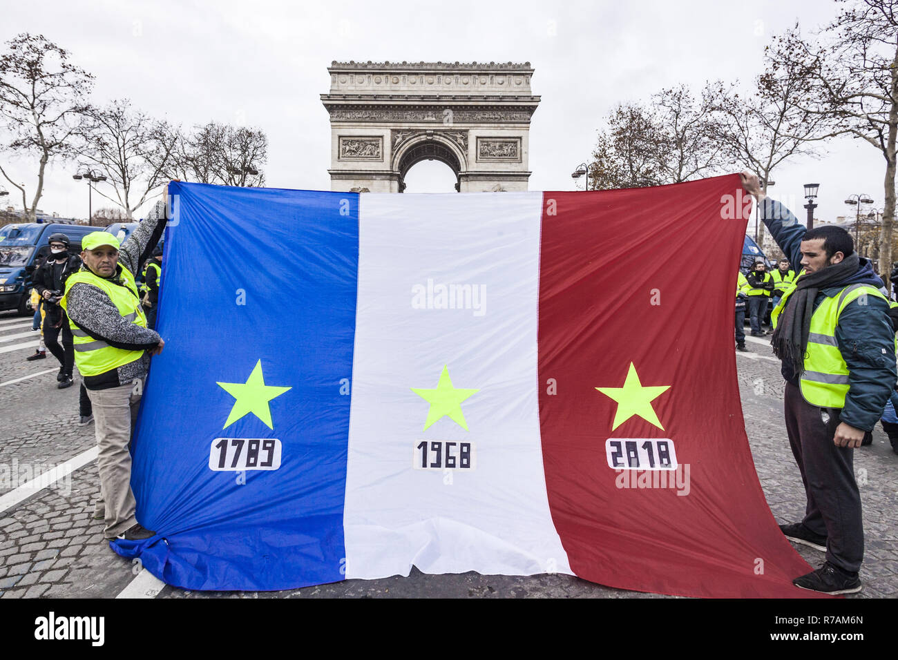 France. 8th Dec, 2018. ''Yellow vest'' protesters extend a France flag with  stars in the dates of the French Revolution 1789, 68Â´s May, and 2018,  revolts against taxes rising in the Avenue