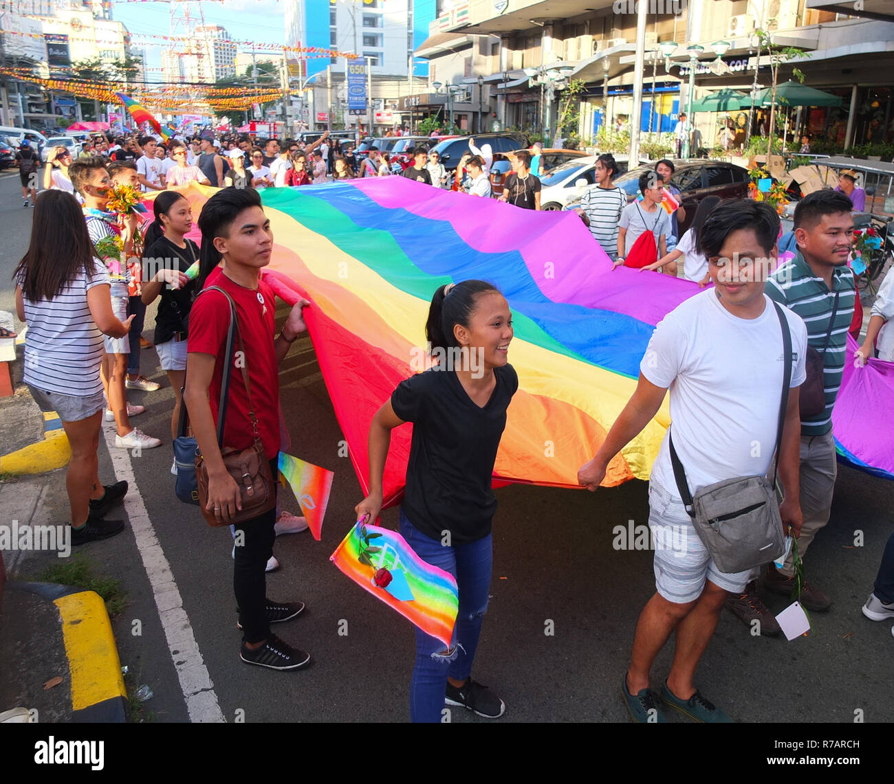 Quezon, Philippines. 8th Dec 2018. People seen holding their huge rainbow flag, symbolizing freedom and equality during the Pride March. The Quezon City Government and the QC Pride Council host again the LGBT Pride March. It's aim is to campaign for HIV ang AIDS prevention and human rights. Credit: SOPA Images Limited/Alamy Live News Stock Photo