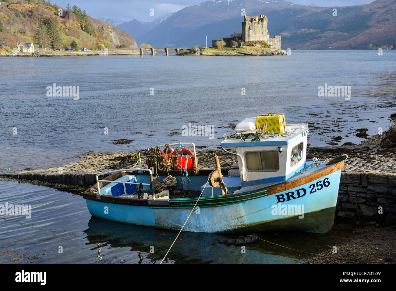 Fishing boat and Eilean Donan Castle at conjuction of Loch Duich, Loch Alsh and Loch Long near Dornie in Wester Ross, Highland Region, Scotland Stock Photo