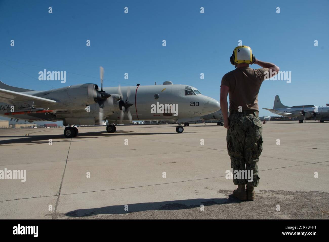 SAN DIEGO (April 12, 2017) Aviation Electronics Technician Airman Nathan McDaniel, attached to Patrol Squadron (VP) 40, salutes a P-3 Orion Aircraft as it taxis to the runway onboard Naval Air Station North Island (NASNI). VP-40 has detached aircraft and personnel to NASNI to support Carrier Strike Group 11 in their Joint Task Force Exercise. Stock Photo