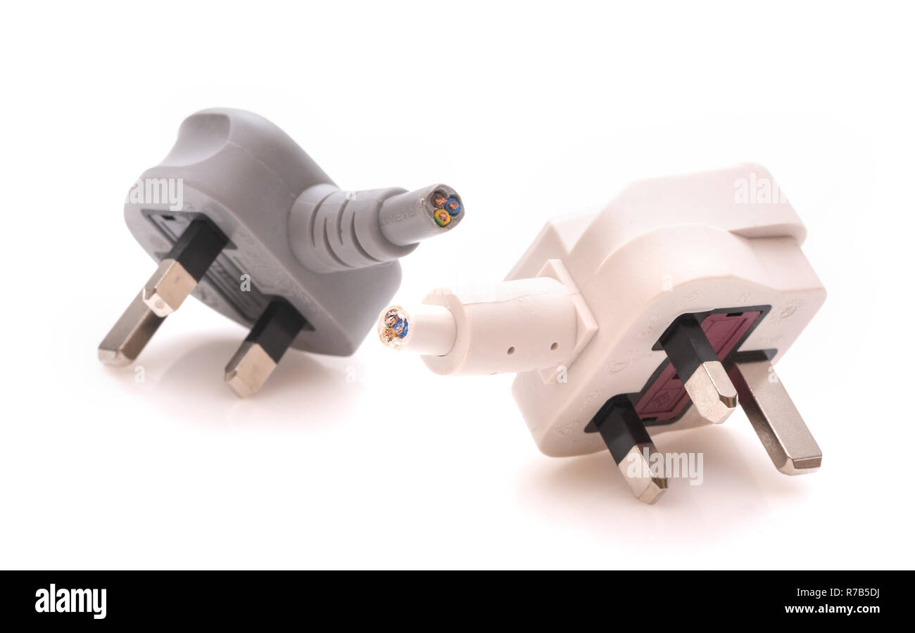 Two cut off 13 amp mains plugs on a white background Stock Photo