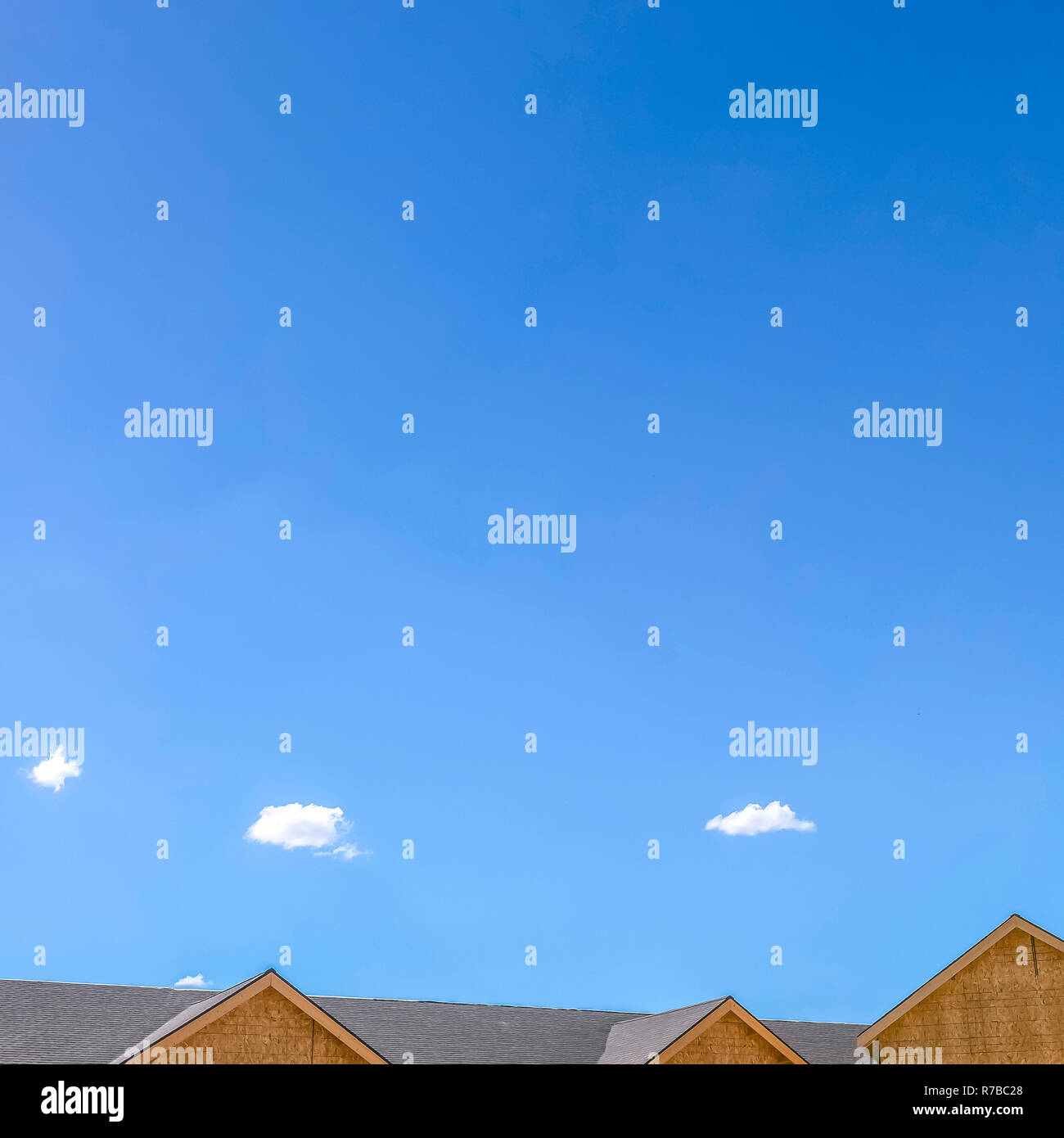Roof of a home against vivid blue sky with clouds Stock Photo - Alamy