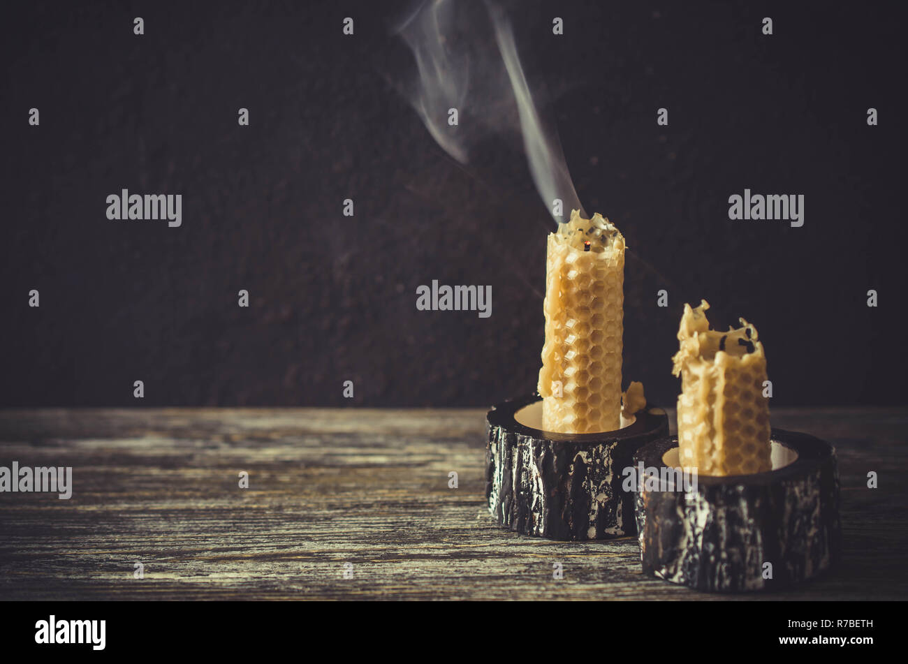 Extinguished wax candles on an old wooden table. Dark mystic background
