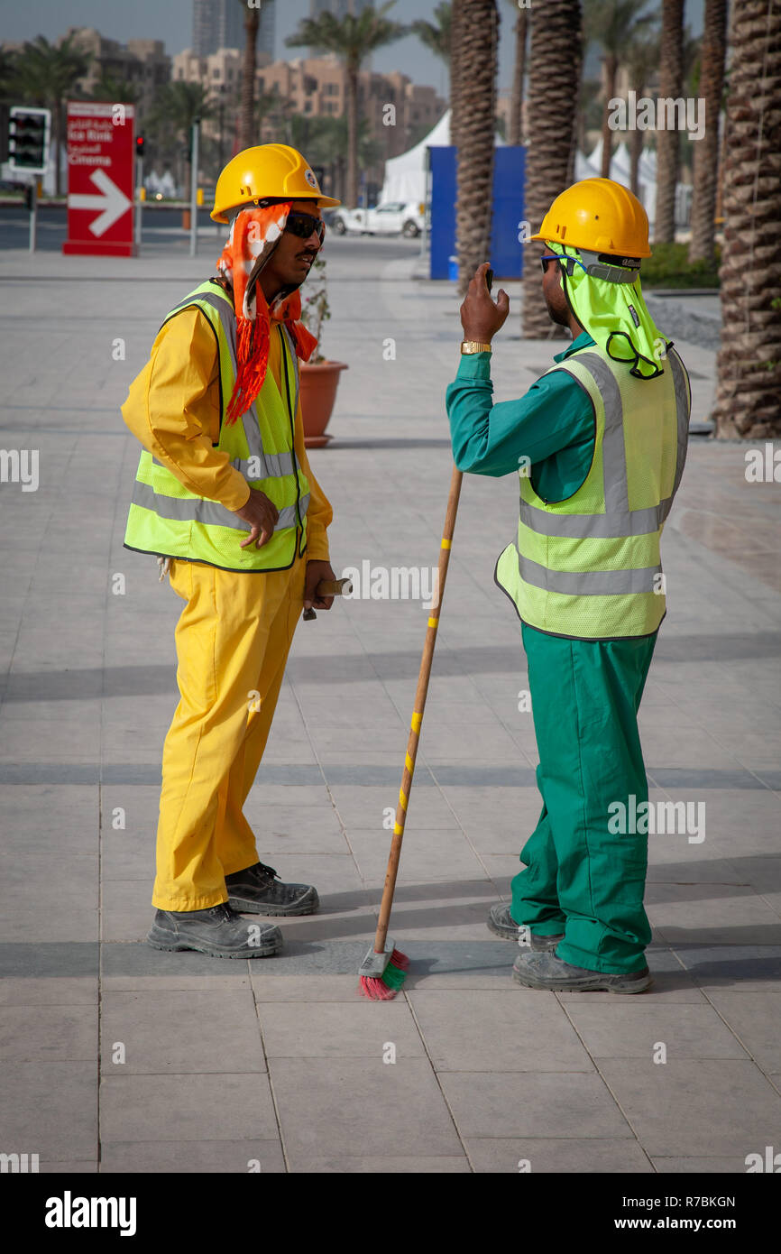 Two building workers talking to each other on a building site in Dubai, UAE Stock Photo