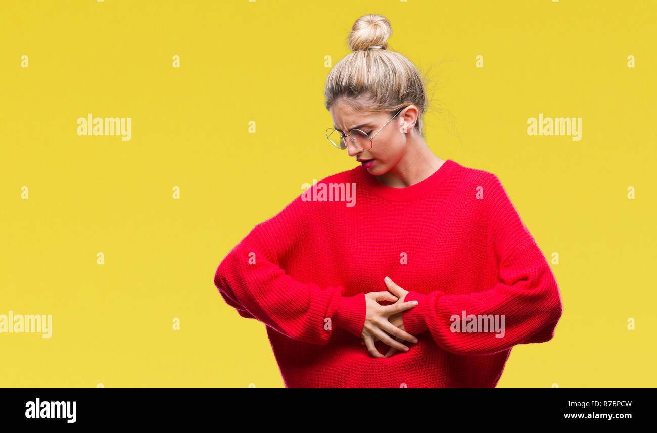 Young beautiful blonde woman wearing red sweater and glasses over isolated background with hand on stomach because indigestion, painful illness feelin Stock Photo