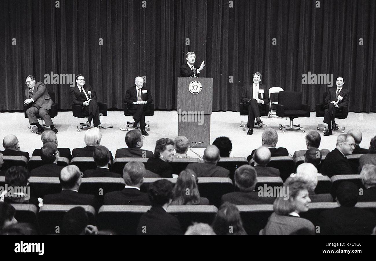 THERE ARE A GROUP OF MEN ON STAGE WITH ONE MAN AT THE PODIUM GIVING A ...