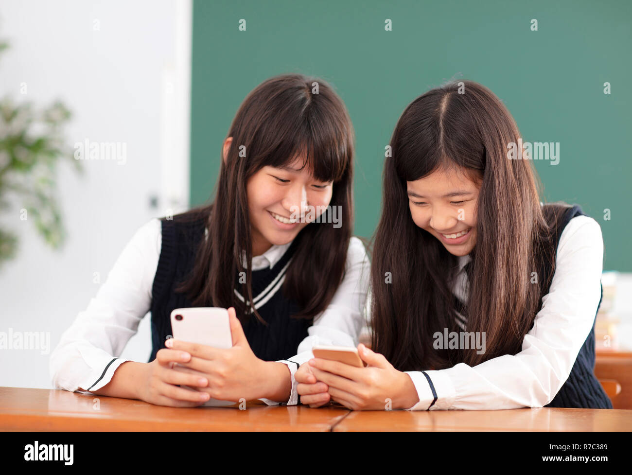teenager girl student watching the smart phone in classroom Stock Photo