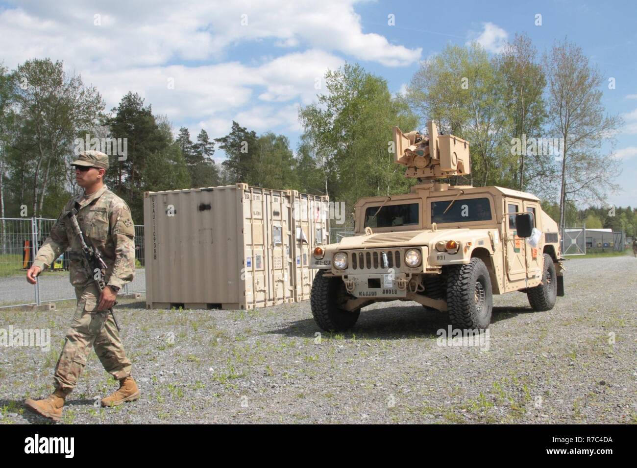 Pfc. Brian Choi, a medic with Company D, 2nd Battalion, 12th Infantry Regiment, 2nd Infantry Brigade Combat Team, 4th Infantry Division, guides a High Mobility Multipurpose Wheeled Vehicle (HMMWV) into a loading yard to download equipment at Camp Kasserine, Grafenwoehr Training Area, Germany on May 17th, 2017. All of the HMMWVs of the 2-12th come loaded with necessary cargo that will allow soldiers to hit the ground running. The 2-12 IN Soldiers flew to Europe with only two weeks of advance notice for an emergency deployment readiness exercise, which showcases the US Army's ability to move tro Stock Photo