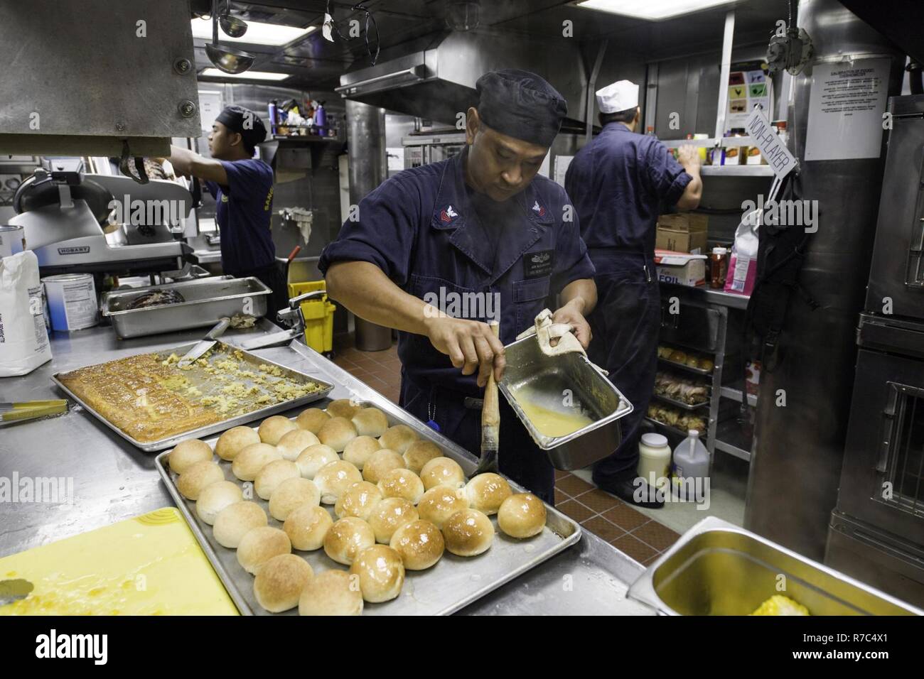SOUTH CHINA SEA(May 14, 2017)   Jun Alejandrino, a native of the Philippines, prepares dinner rolls in the galley aboard the Arleigh Burke-class guided-missile destroyer USS Dewey (DDG 105).  Dewey is part of the Sterett-Dewey Surface Action Group and is the third deploying group operating under the command and control construct called 3rd Fleet Forward.  The U.S. 3rd Fleet operating forward offers additional options to the Pacific Fleet commander by leveraging the capabilities of 3rd and 7th Fleets. Stock Photo
