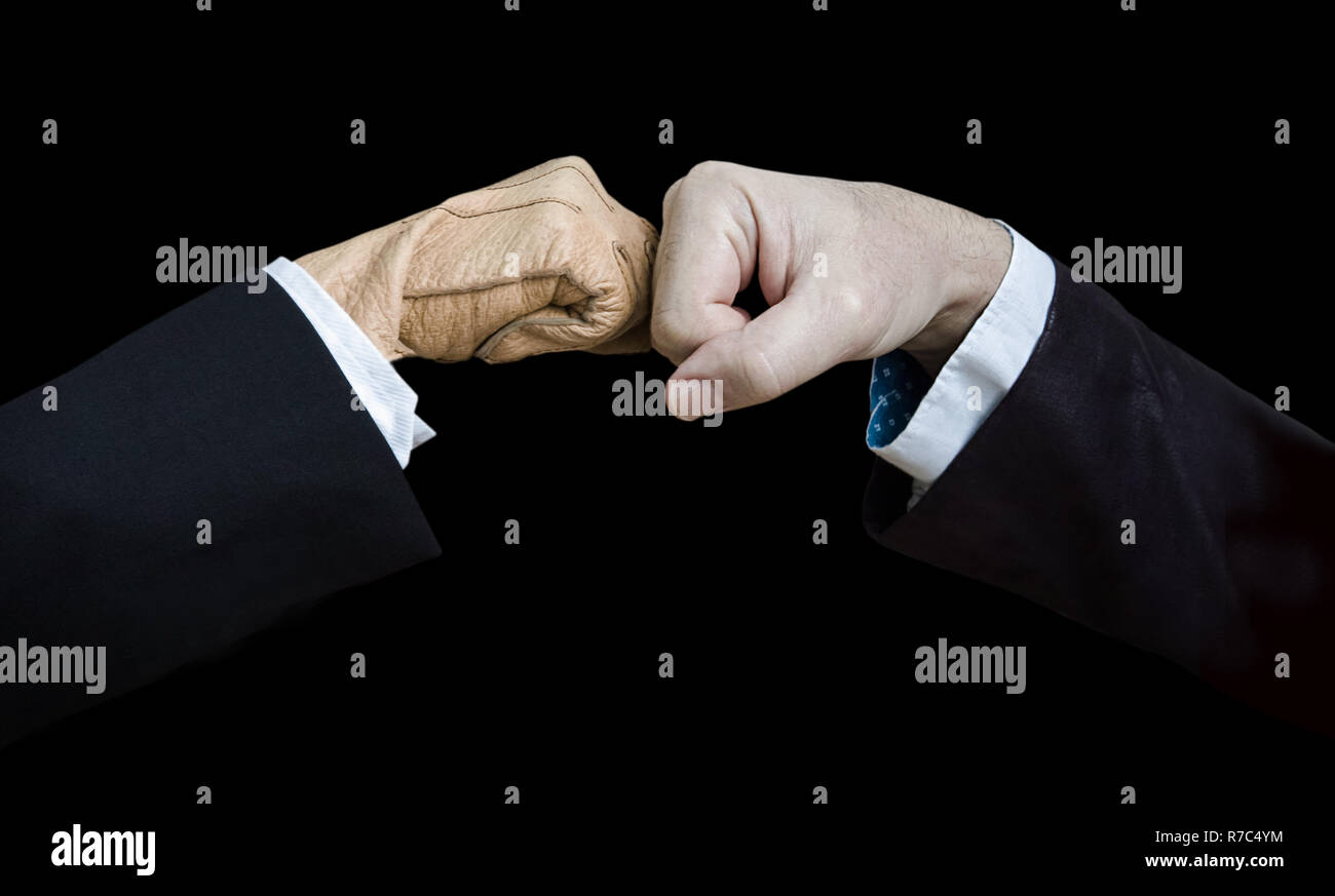 Fist bump, the female hand is gloved. Low key. Stock Photo