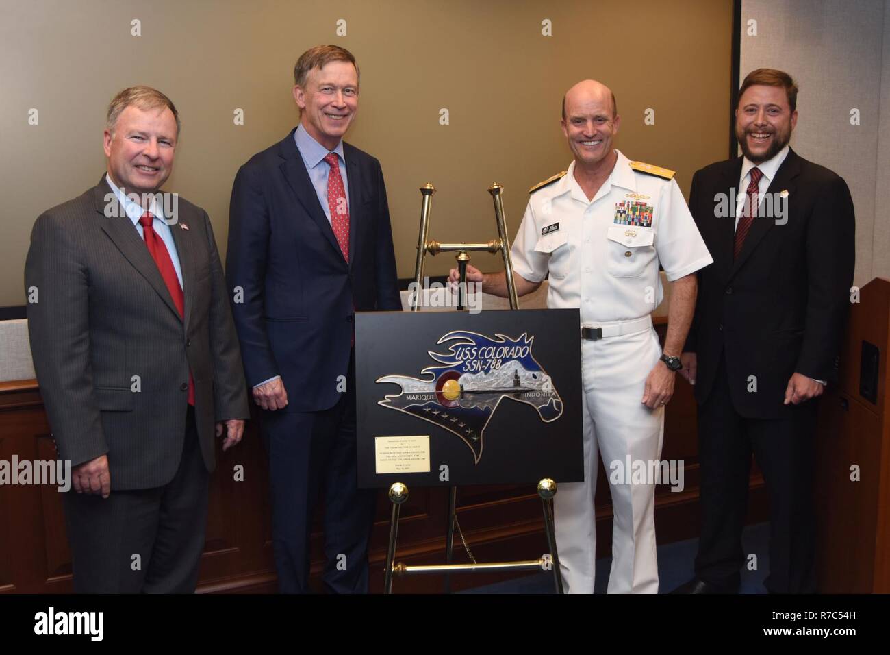 WASHINGTON (May 16, 2017) U.S. Rep. Doug Lamborn, left, from Colorado's 5th Congressional District,  Colorado Gov. John Hickenlooper and Christian Anschutz, right, managing director of Western Development Group, present a plaque with the crest of USS Colorado (SSN 788) to Rear Adm. William R. Merz, director of Undersea Warfare Division, at the Pentagon. Colorado was christened in December 2016 and is scheduled to be commissioned in December 2017. Stock Photo