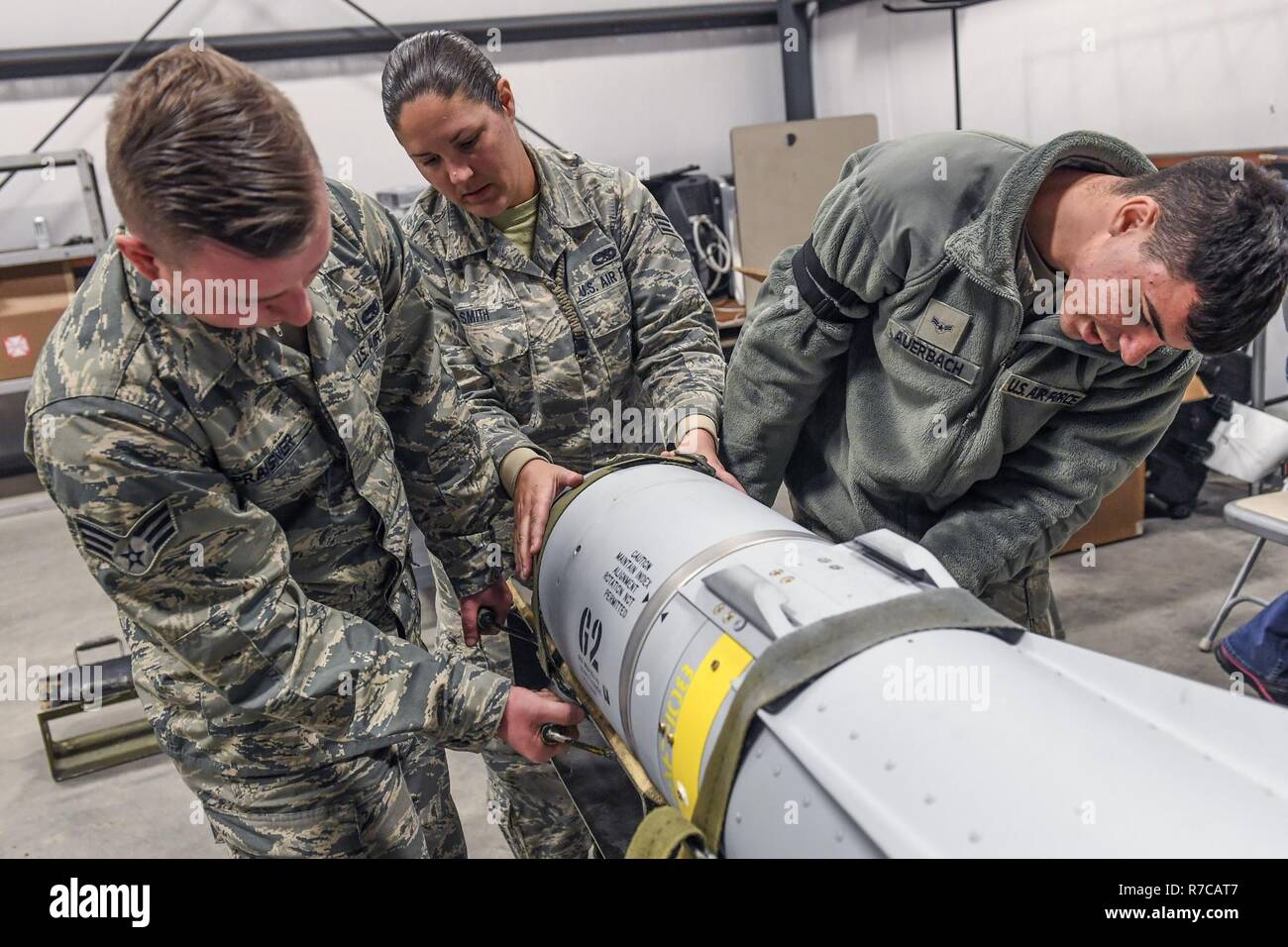 From the left, Senior Airman Troy Praisner, Senior Airman Lauren Smith and Airman 1st Class Anthony Auerbach, all from the 23rd Equipment Maintenance Squadron, Moody Air Force Base, Georgia, remove the guidance control system from an AGM-65 Maverick air-to-surface guided missile at Hill Air Force Base, Utah, April 26. The Airmen participated in Combat Hammer, an air-to-ground weapons evaluation exercise conducted by the 86th Fighter Weapons Squadron which collects and analyzes data on the performance of precision weapons and measures their suitability for use in combat. Stock Photo