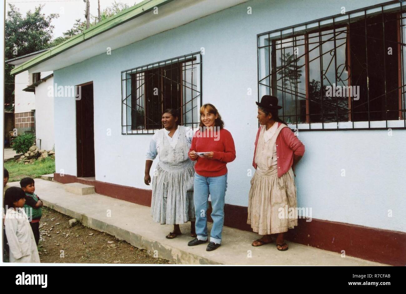 THREE WOMEN STANDING IN FRONT OF A BUILDING WITH THE CHILDREN WATCHING ...