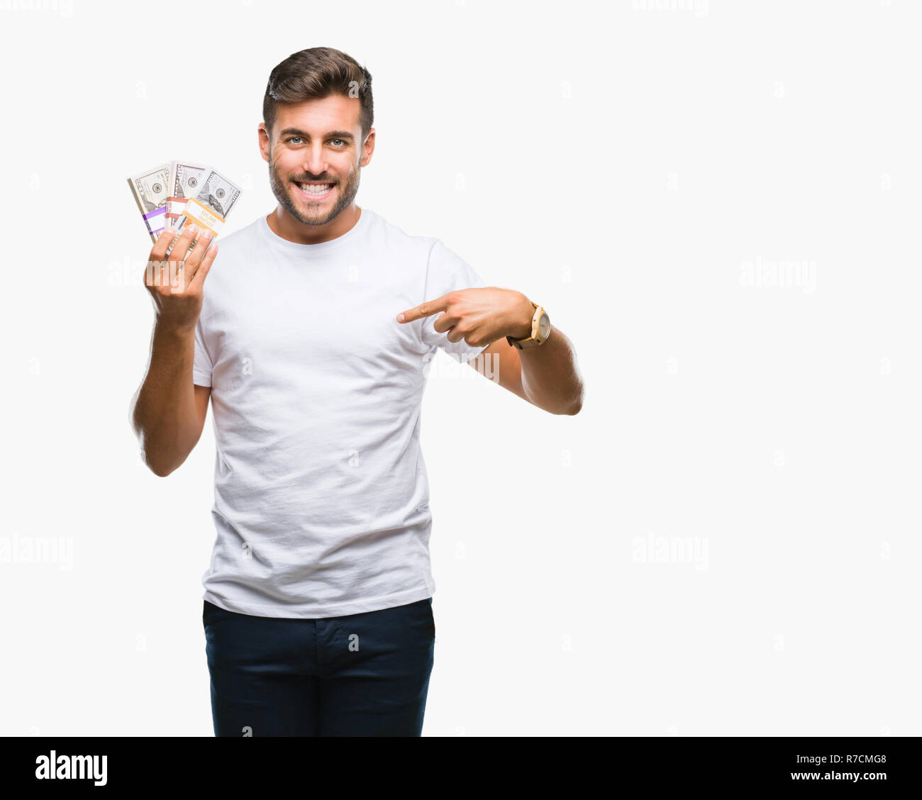 Young handsome man holding stack of dollars over isolated background ...