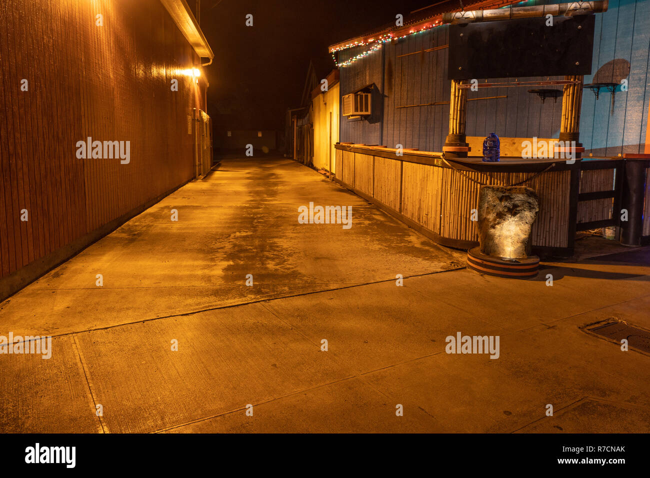 Yellow light illuminating an empty alley at night, Kapa'a, Kaua'i, Hawai'i Stock Photo