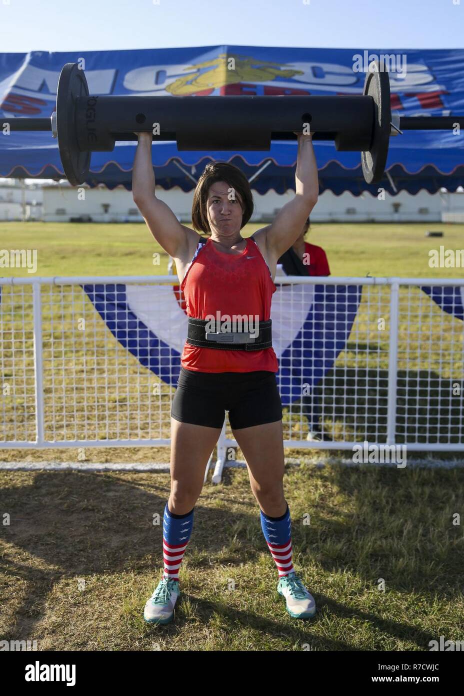 U.S. Navy Lt. Kimberly Pistell, battalion surgeon with Marine Wing Support Squadron-172, performs an overhead clean and press during the Okinawa’s Strongest competition on Camp Foster, Okinawa, Japan, Dec. 1, 2018. The event was held to encourage friendly competition through physical challenges like deadlifts, sled pulls, atlas stone lifts and tire flips. Stock Photo