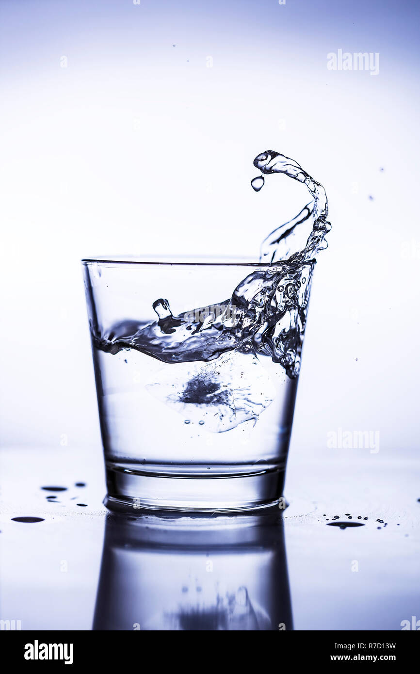 Splash ice cubes in a water glass Stock Photo - Alamy