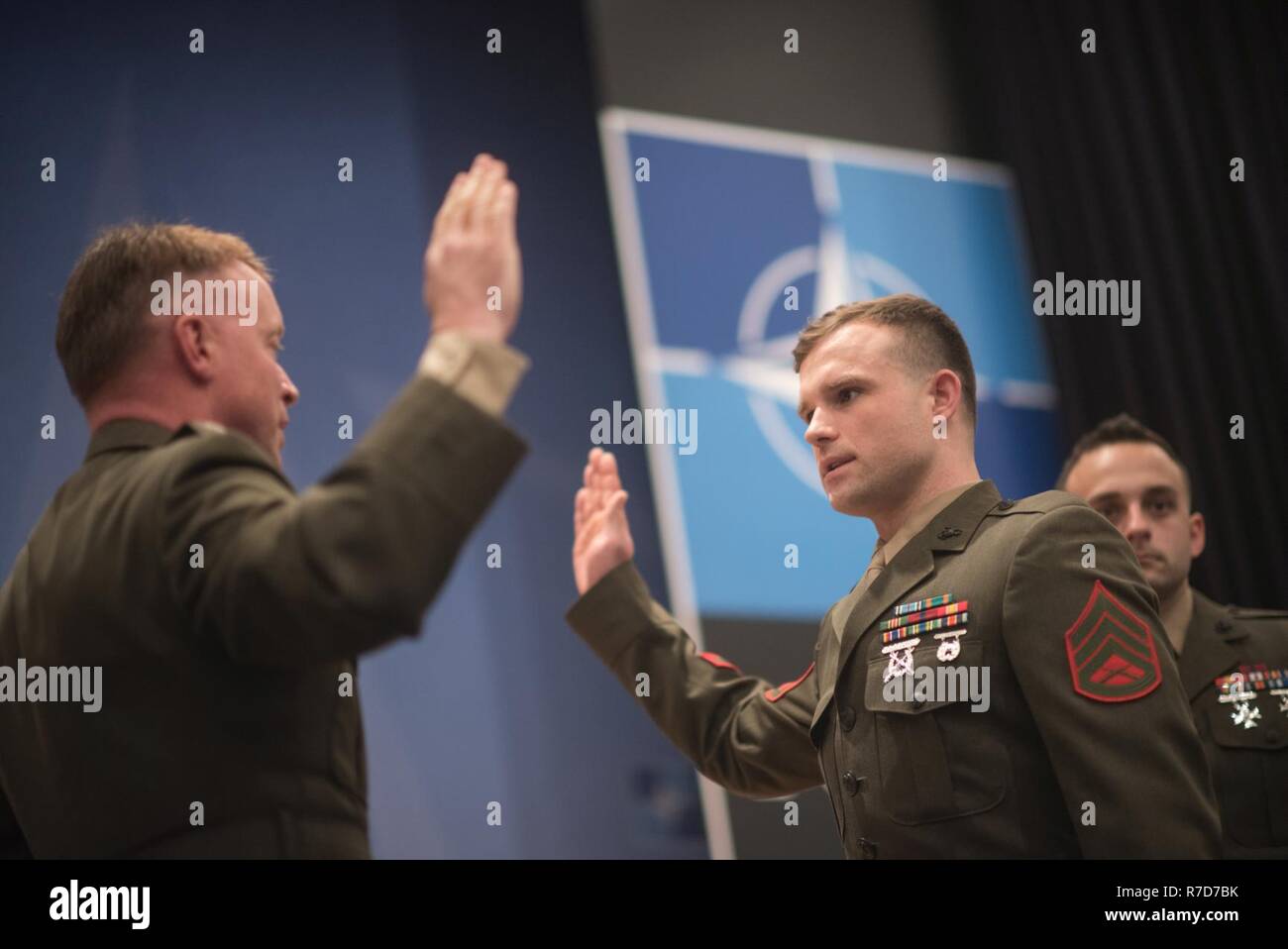 U.S. Marine Col. Philippe Rogers, U.S. Military Delegation to the North Atlantic Treaty Organization (NATO) Chief of Staff, conducts a Re-enlistment ceremony for Staff Sgt. Matthew Leonard, U.S. Marine Guard detachment of the U.S. Embassy to NATO,  at NATO Headquarters, May 17, 2017. (DoD Stock Photo