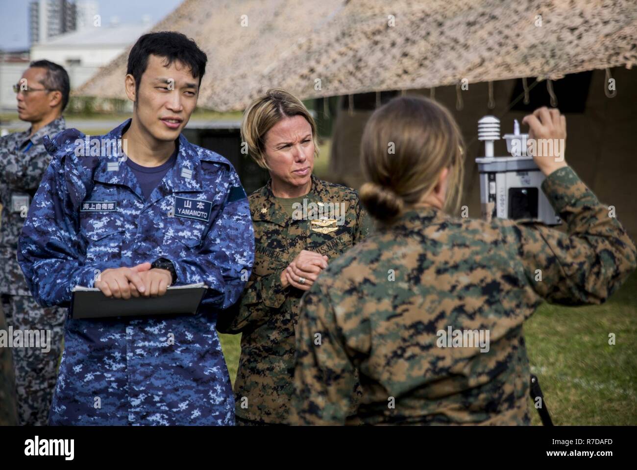 U.S. Navy medical officers with the Preventive Medical Team (PMT) demonstrate the functions of the Wet Bulb Globe Thermometer (WBGT) to Japanese service members during the capabilities display Nov. 28, 2018 at Camp Foster, Okinawa, Japan. The WBGT gives service members the ability to accurately measure wind speed, humidity and temperature. Sailors with 3rd Medical Battalion, 3rd Marine Logistics Group, established a Role II capabilities display to give service members the opportunity to view their full facilities. The PMT displayed and offered courses on their food and water sanitation test, s Stock Photo