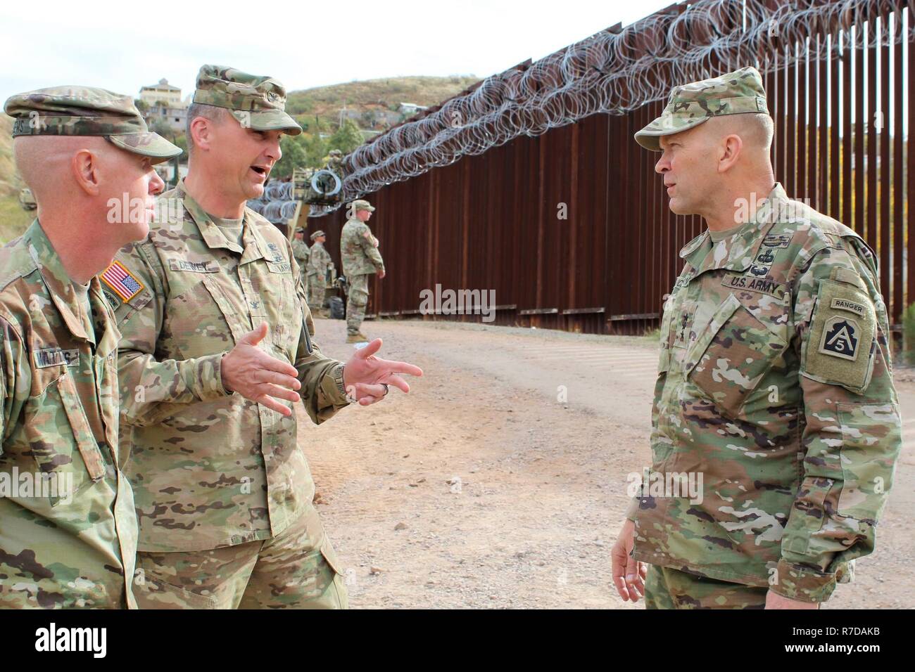 Col. Larry Dewey, 16th Military Police Brigade Commander, center, talks to Lt. Gen. Jeffrey Buchanan, United States Army North Commanding General, right, and Cpt. Charles Matthews, 104th Engineer Construction Company, left, about work complete on the border wall near Nogales, Arizona, Nov. 29, 2018. Northern Command is providing military support to the Department of Homeland Security and U.S. Customs and Border Protection to secure the southern border of the United States. Stock Photo